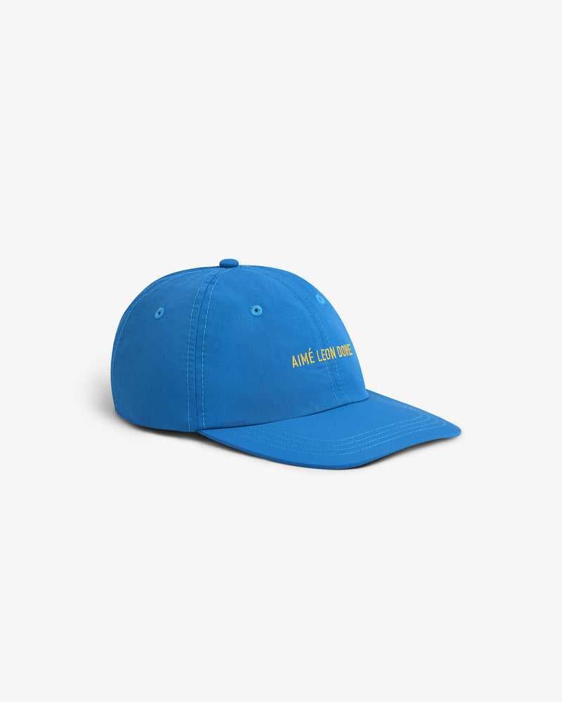 Nylon Sport Hat in blue with yellow Aimé Leon Dore text embroidered on the front, shown on a white background.