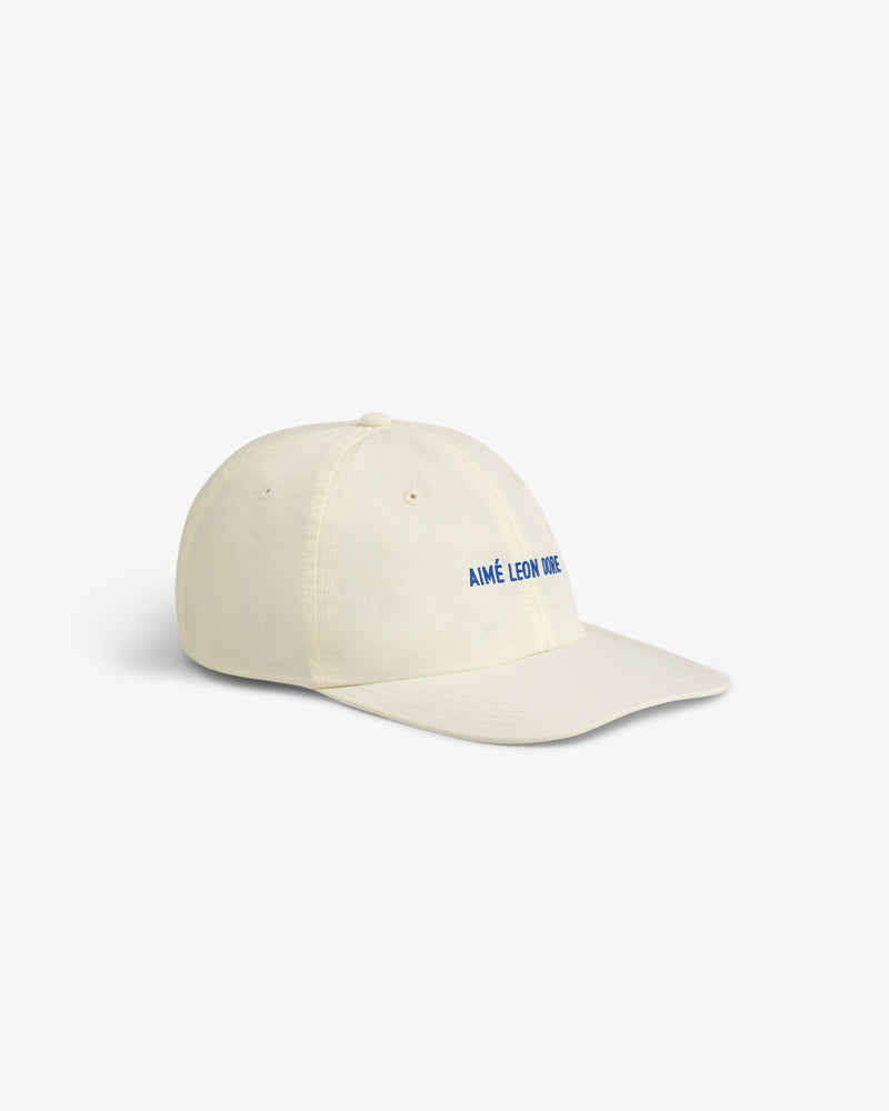 Cream-colored Nylon Sport Hat with AIMÉ LEON DORE in blue on the front, set against a white background.