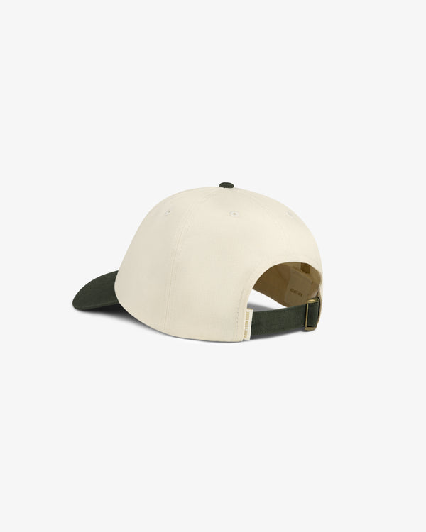 The Saint George Logo Hat is a beige cap with a dark green brim and adjustable strap, shown from the back.