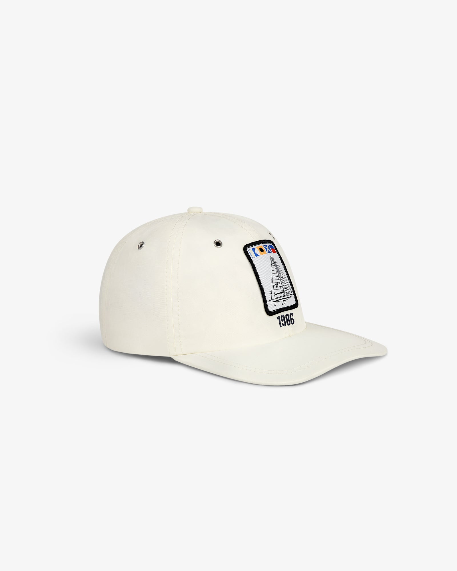 Nylon Deck Hat in off-white with a front patch of a sailboat, flags, and "1986" embroidery.