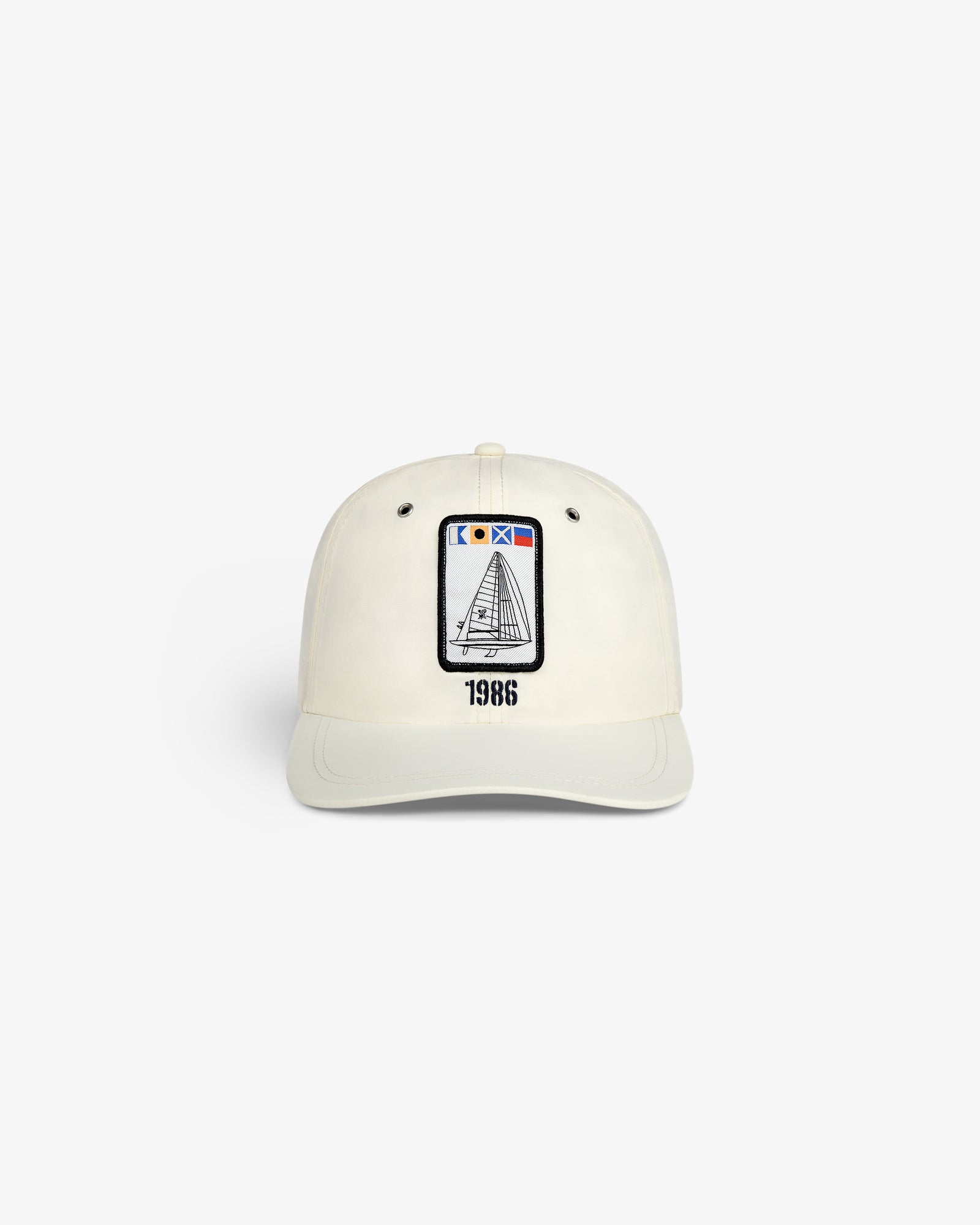 Front view of the Nylon Deck Hat in off-white with a sailboat patch and "1986" embroidered below.