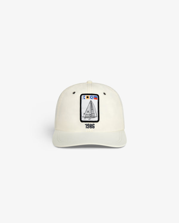 Front view of the Nylon Deck Hat in off-white with a sailboat patch and "1986" embroidered below.