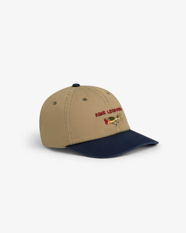 Tan and navy Colorblock Lure Hat with cartoon dog embroidery and red ANGE LEON DORE text.