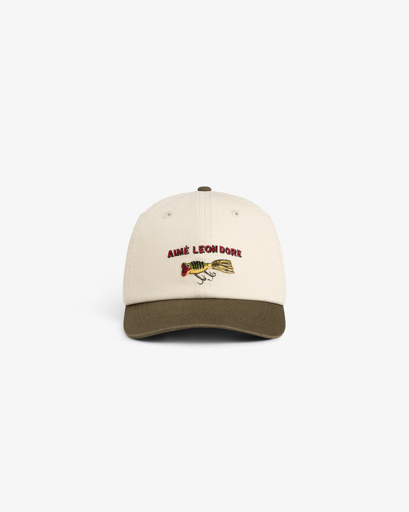Colorblock Lure Hat: Beige cap with olive brim, AIMÉ LEON DORE text, and fish graphic on the front.