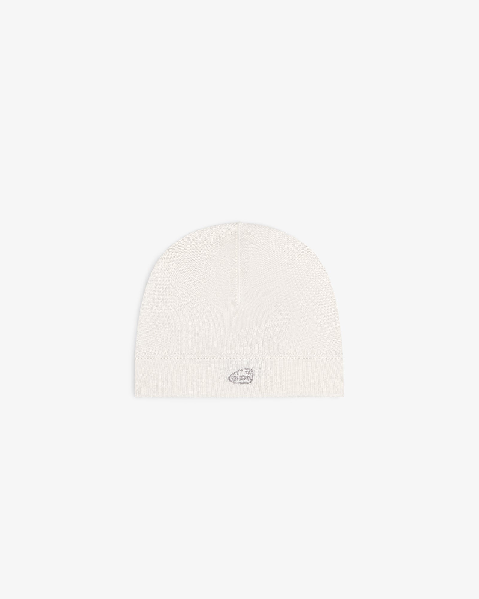 The ALD Golf Skull Cap is a plain white beanie with a small gray oval logo on the front, shown on a white background.