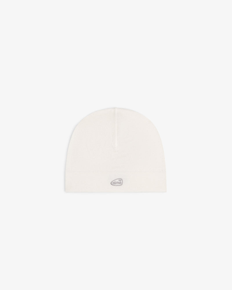 The ALD Golf Skull Cap is a plain white beanie with a small gray oval logo on the front, shown on a white background.
