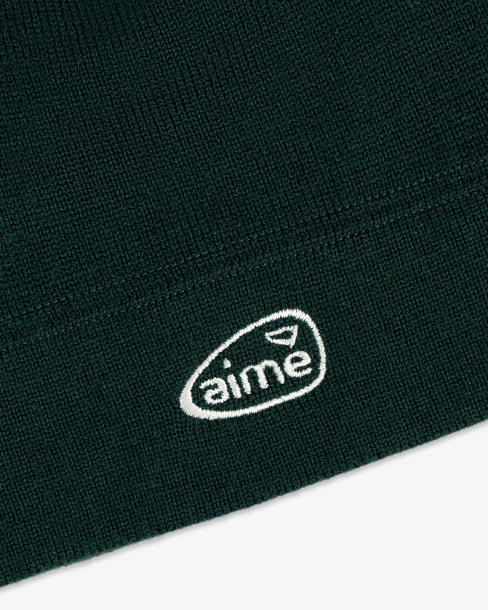 Dark green ALD Golf Skull Cap with a small white oval "aime" logo and a triangle above the text.