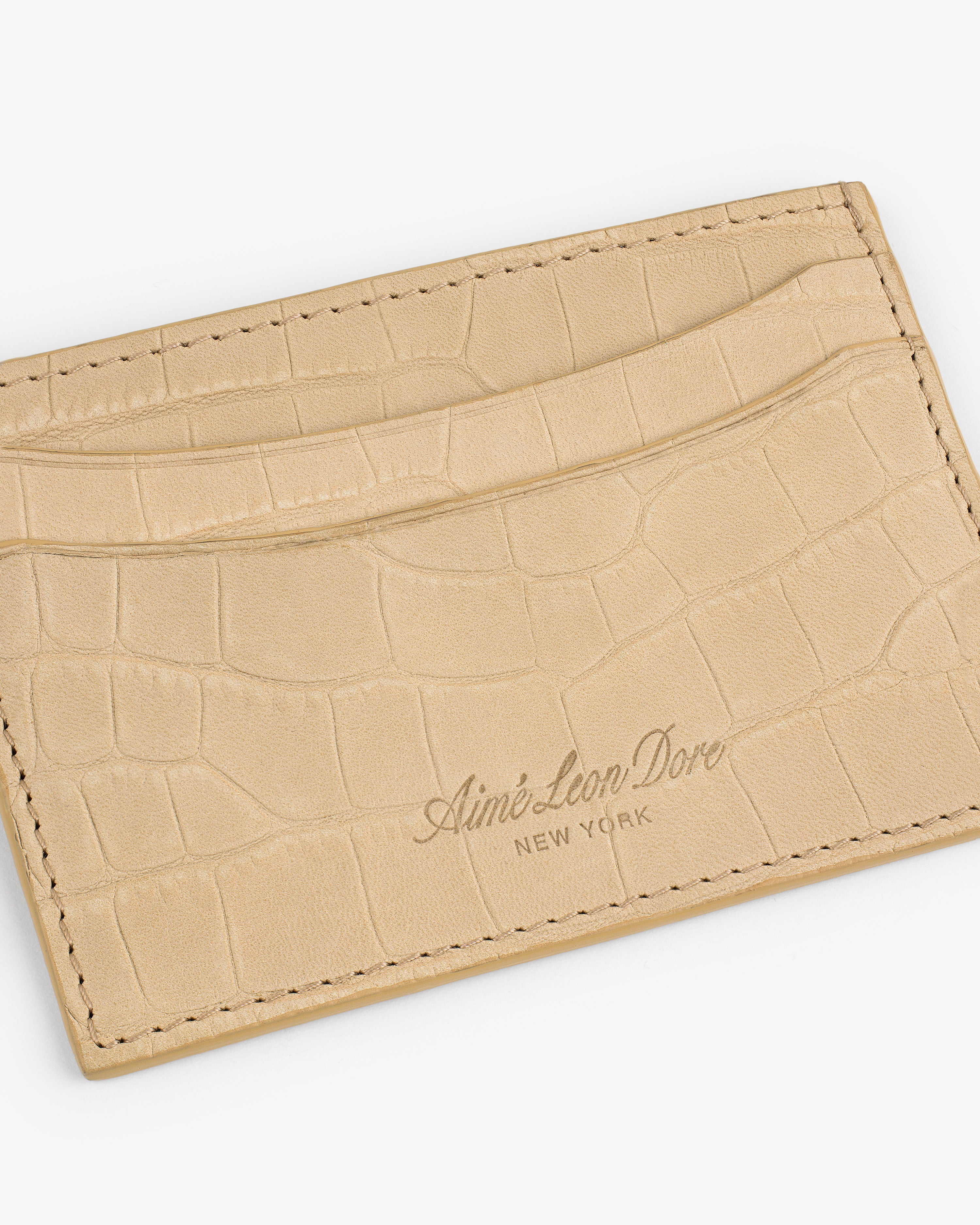 Beige Croc-Embossed Nubuck Cardholder with “Aimé Leon Dore New York” embossed on the front.