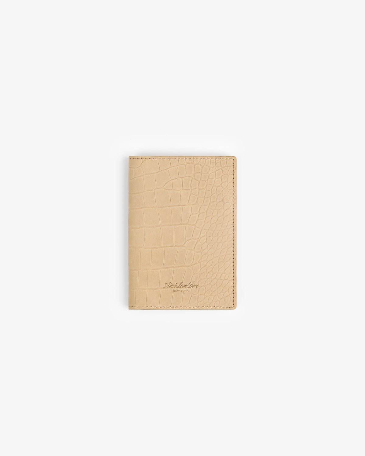 Croc-Embossed Nubuck Passport Holder in beige shown on a plain white background with subtle embossed texture.