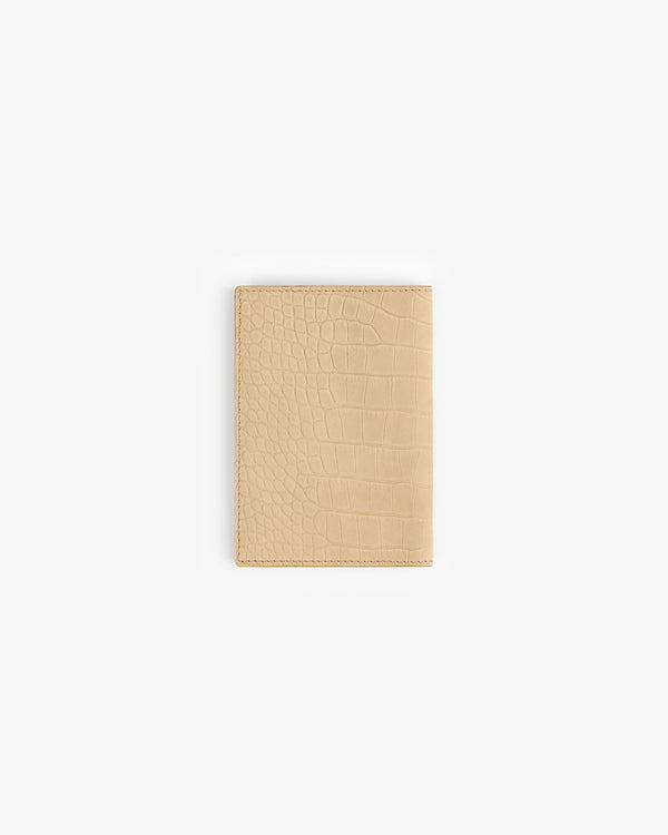 The Croc-Embossed Nubuck Passport Holder in beige shown on a plain white background.