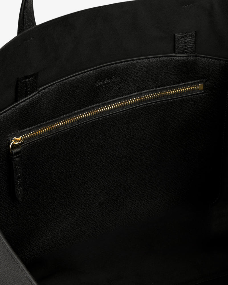 Close-up of the Full Grain Leather Tote Bag's gold zipper pocket and black fabric lining.