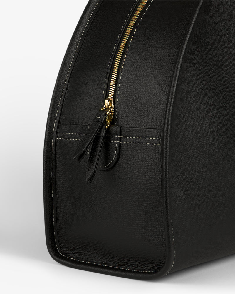 Close-up of the Full Grain Leather Weekender Bag in black with a gold zipper and visible stitching on a plain background.