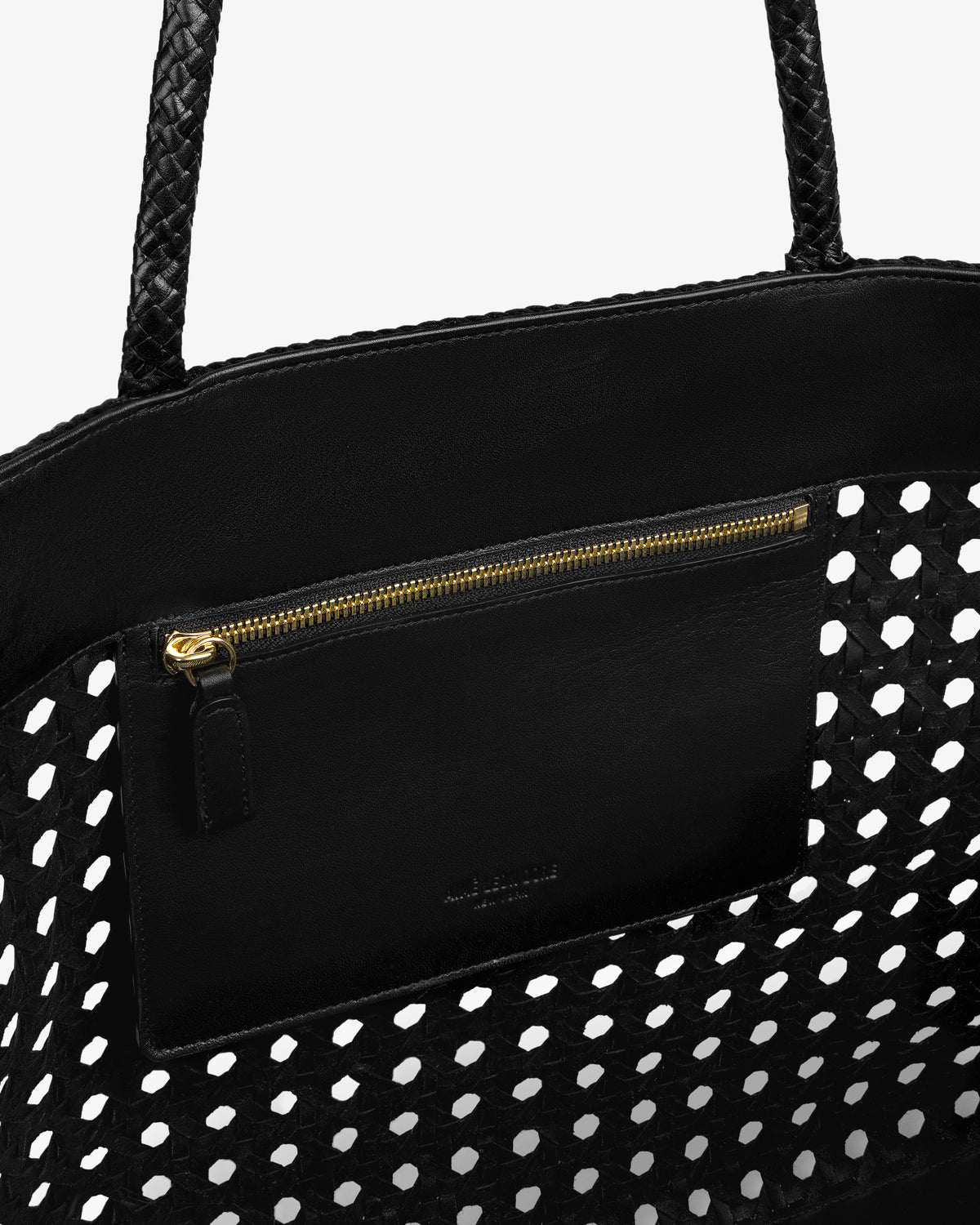 Close-up of the Woven Leather Tote Bag’s zippered pocket with gold pull inside the black woven interior.