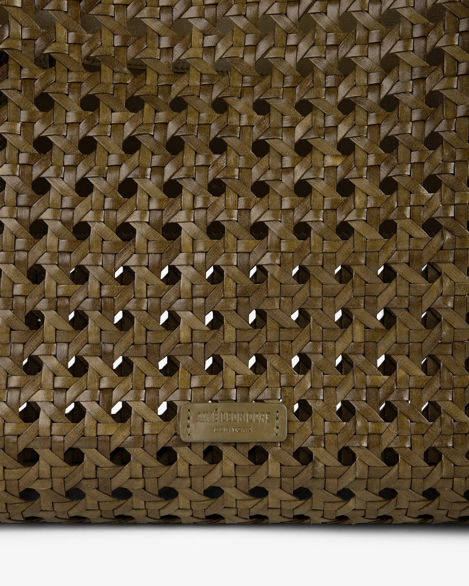 Close-up of the Woven Leather Tote Bag in brown, featuring a small embossed AMI PARIS label at the bottom.