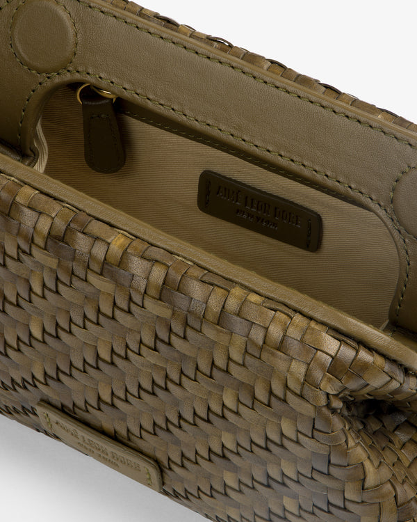 Close-up of a Woven Leather Shoulder Bag in brown with open flap, showing interior label reading Aime Leon Dore.