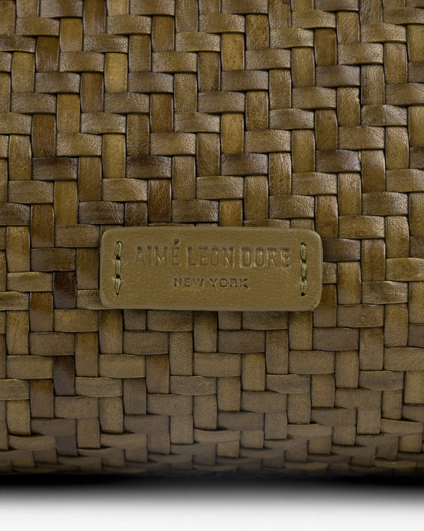 Close-up of the Woven Leather Shoulder Bag with an AIMÉ LEON DORE NEW YORK label stitched on the front.