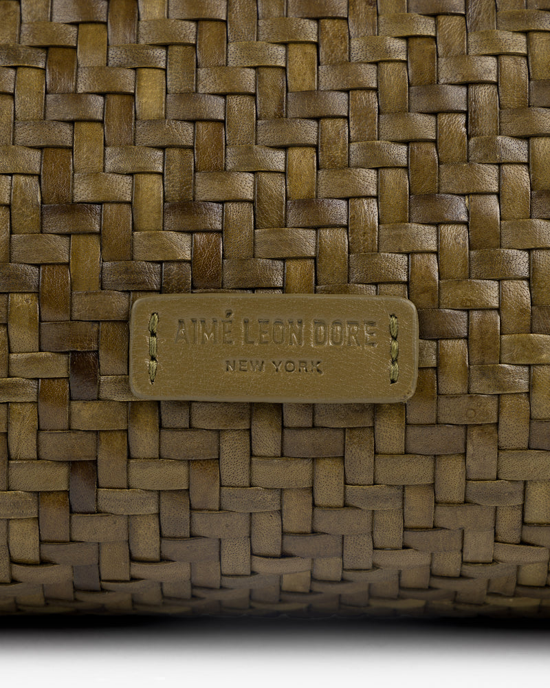 Close-up of the Woven Leather Shoulder Bag with an AIMÉ LEON DORE NEW YORK label stitched on the front.