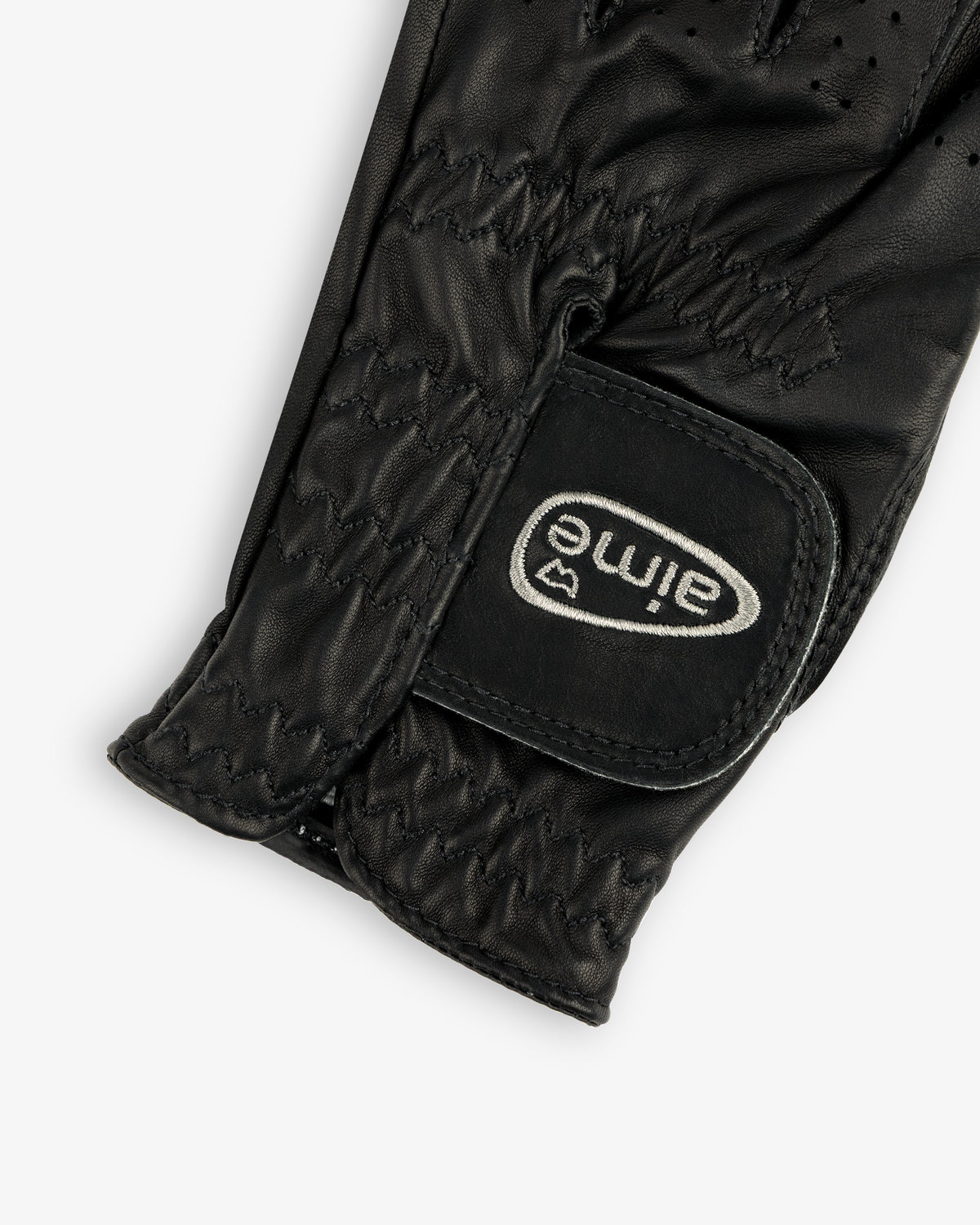 Close-up of the ALD / FootJoy StaSof Heritage Glove (Left), black leather with visible stitching and aimé Velcro strap.