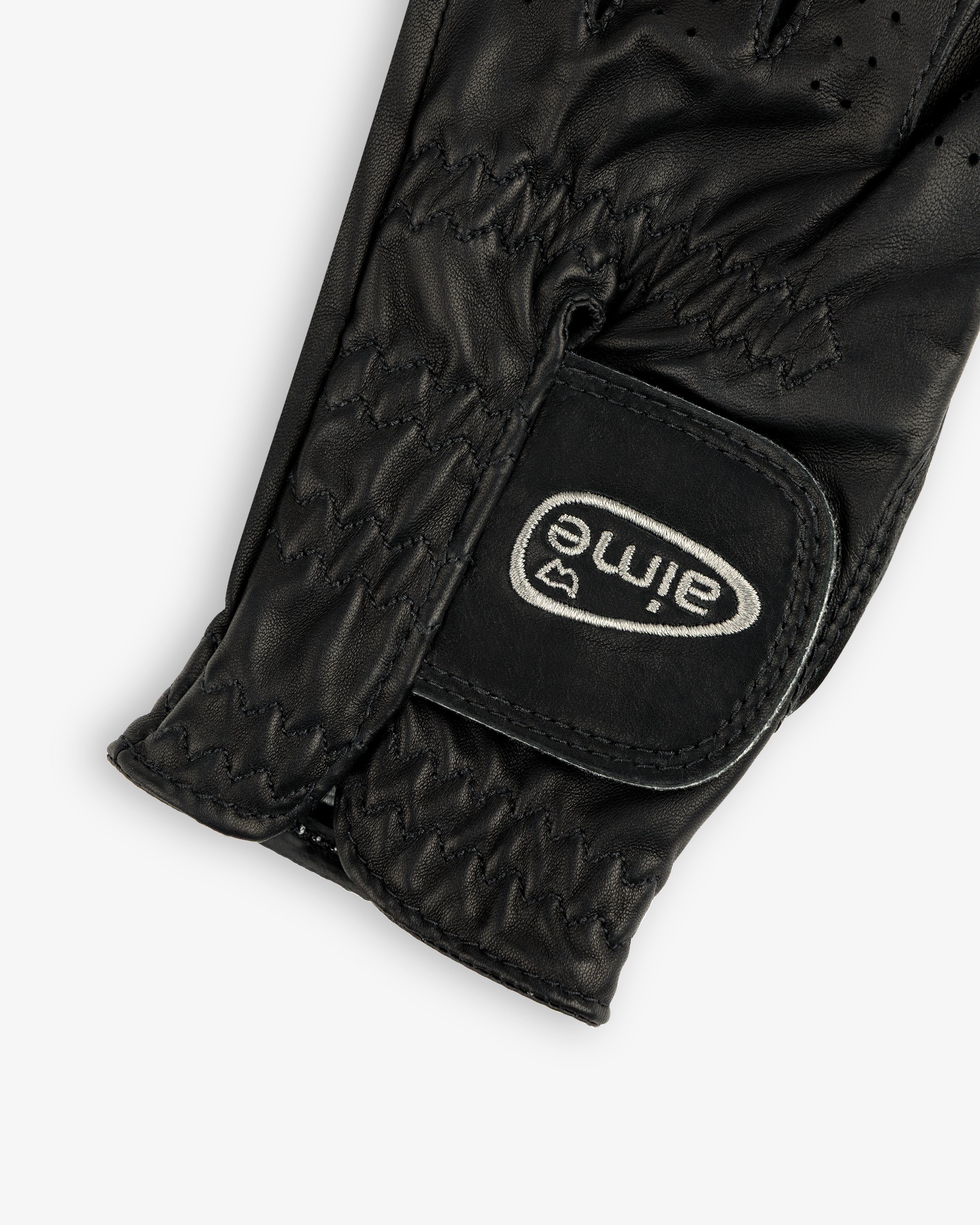 Close-up of the ALD / FootJoy StaSof Heritage Glove (Left), black leather with visible stitching and aimé Velcro strap.