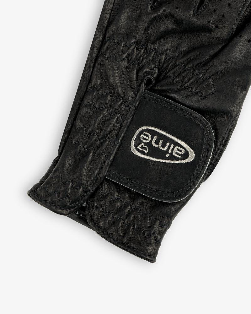 Close-up of the ALD / FootJoy StaSof Heritage Glove (Left), black leather with visible stitching and aimé Velcro strap.