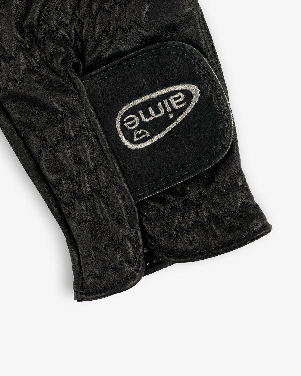 Close-up of the ALD / FootJoy StaSof Heritage Glove (Left), black leather with stitching and a white aimé Velcro strap.