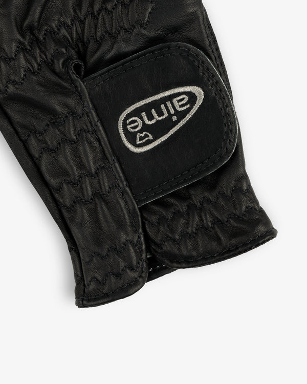 Close-up of the ALD / FootJoy StaSof Heritage Glove (Left), black leather with stitching and a white aimé Velcro strap.