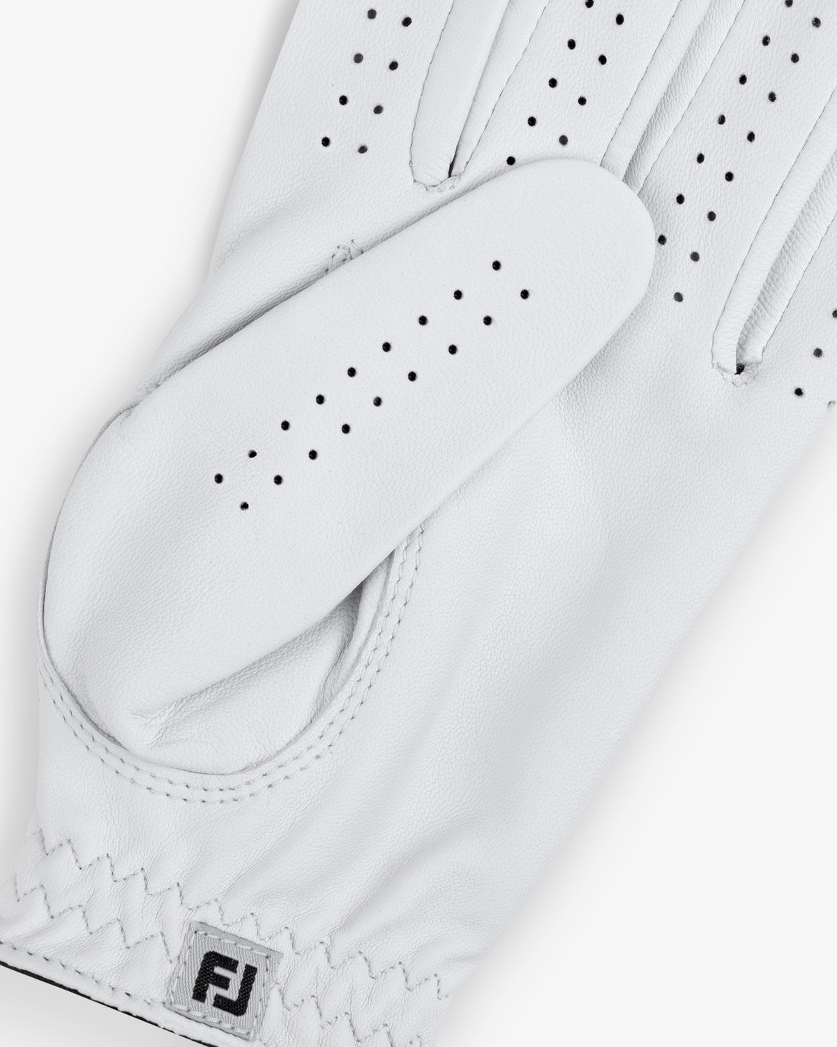 Close-up of the ALD / FootJoy StaSof Heritage Glove (Left) in white with small ventilation holes and FJ logo on wrist.