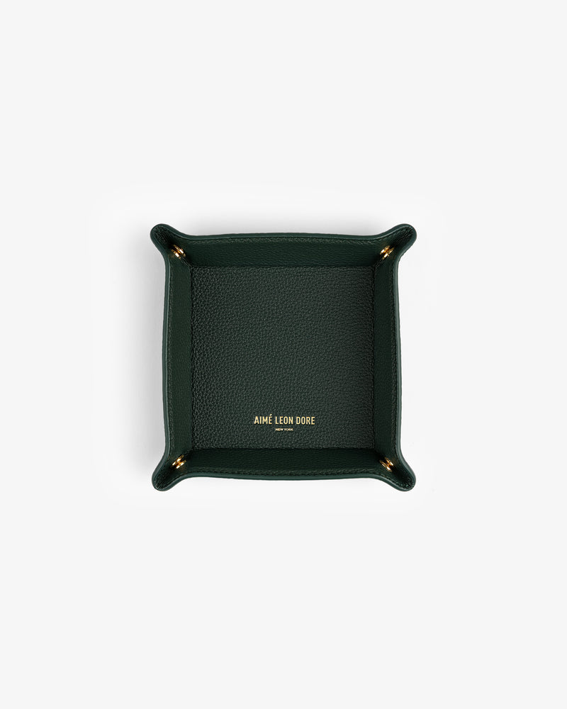 Dark green Leather Catchall with gold Aimé Leon Dore text in the center, shown from above on a white background.