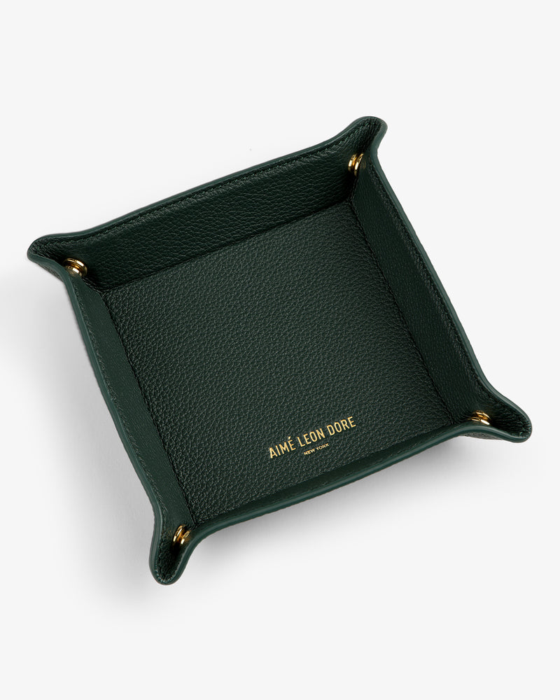 Dark green Leather Catchall with gold AIMÉ LEON DORE text at center and gold snaps on each corner.