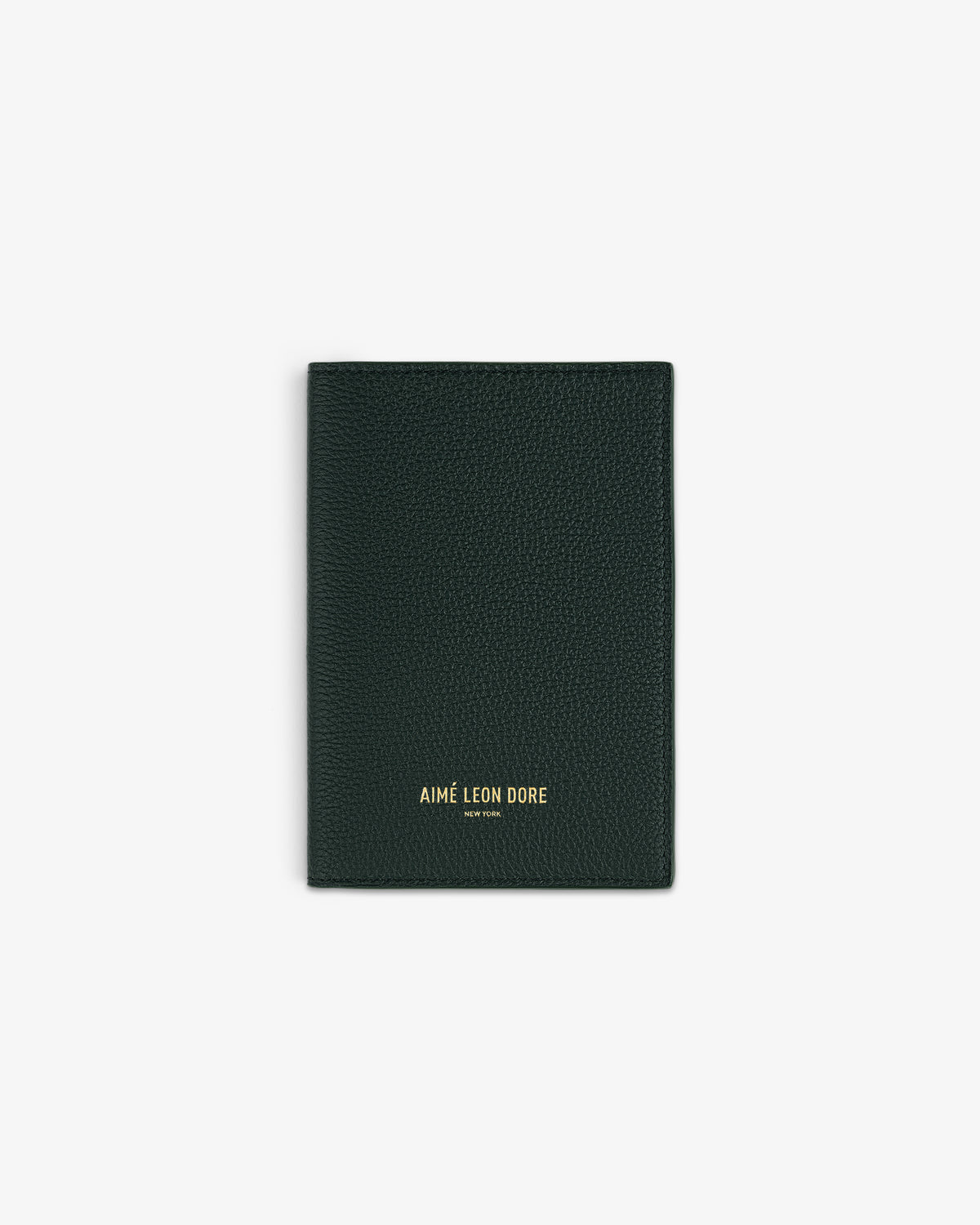 Dark green leather passport holder with AIMÉ LEON DORE NEW YORK embossed in gold on the front, centered on white.
