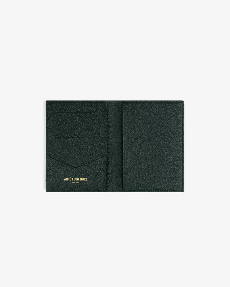 Dark green Leather Passport Holder open, showing card slots and AIMÉ LEON DORE in gold on the left side.