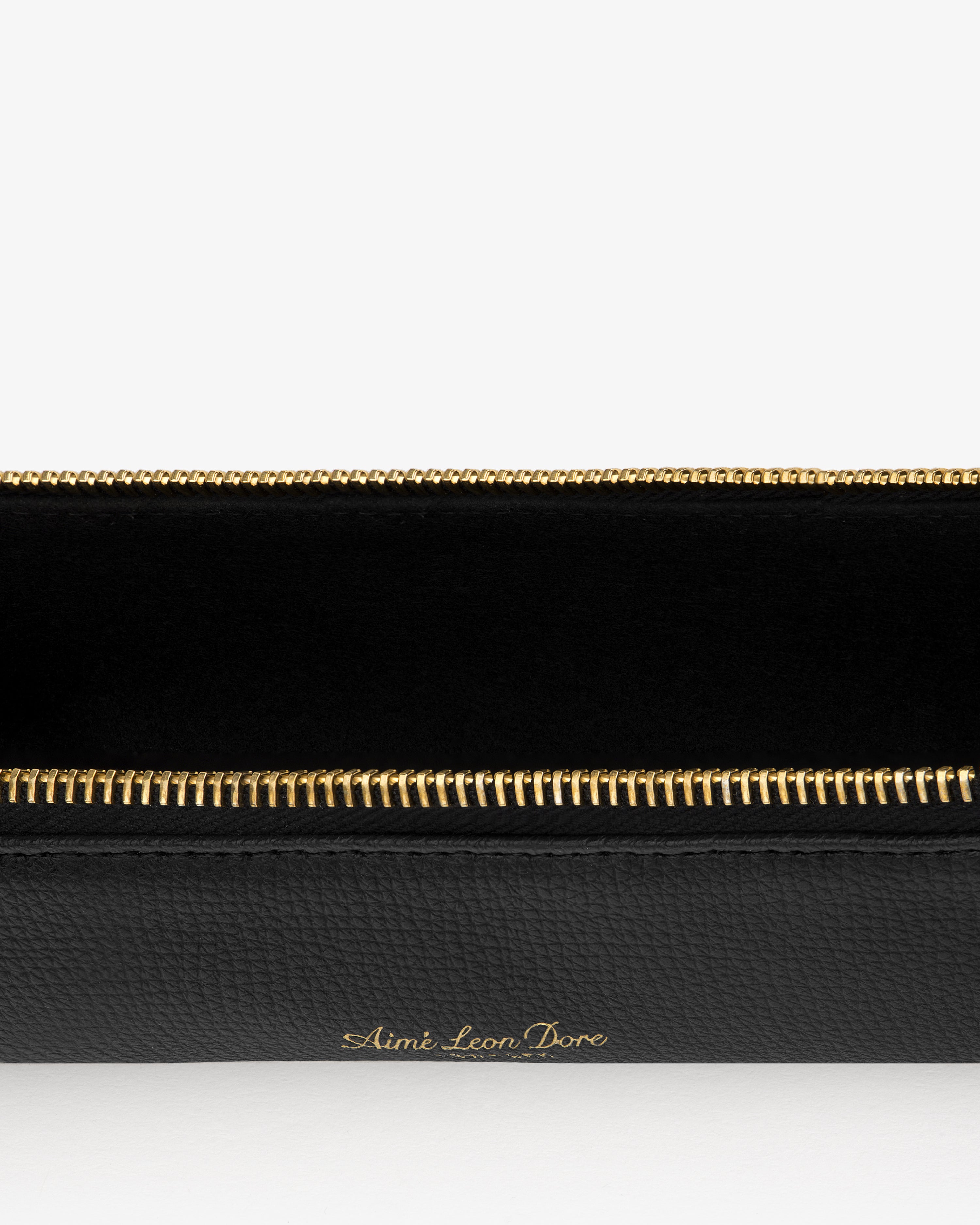 Black Leather Pencil Case with gold zipper, Aimé Leon Dore embossed in gold lettering on the front.