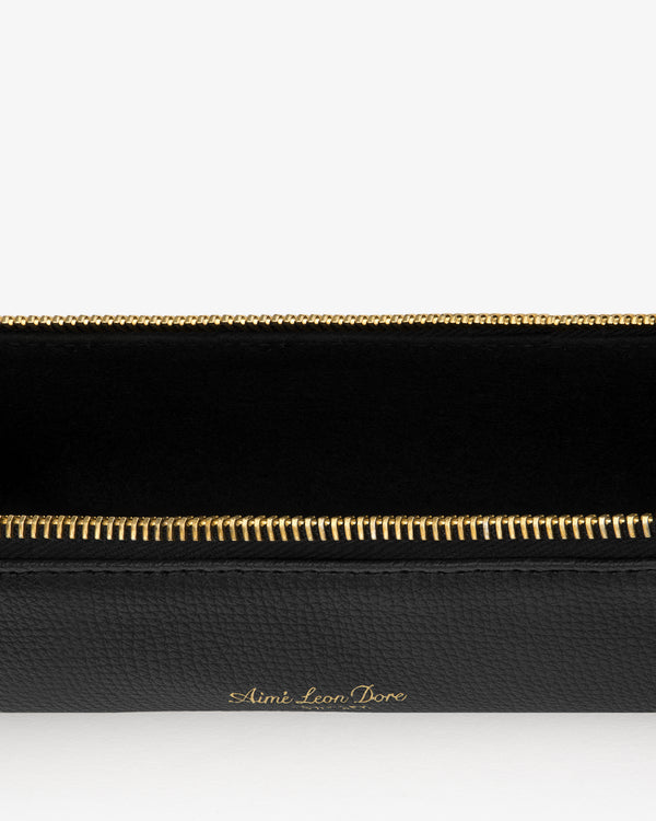 Black Leather Pencil Case with gold zipper, Aimé Leon Dore embossed in gold lettering on the front.