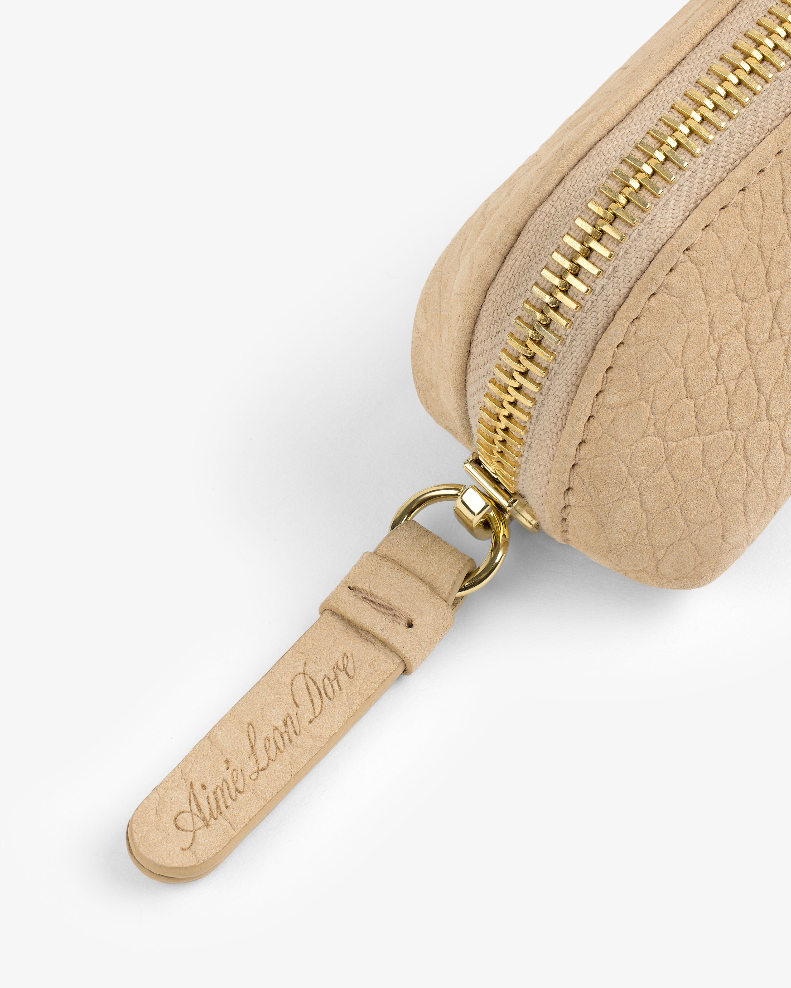 Close-up of the Croc-Embossed Nubuck Pencil Case featuring a gold zipper and leather pull tab engraved with Aimé Leon Dore.