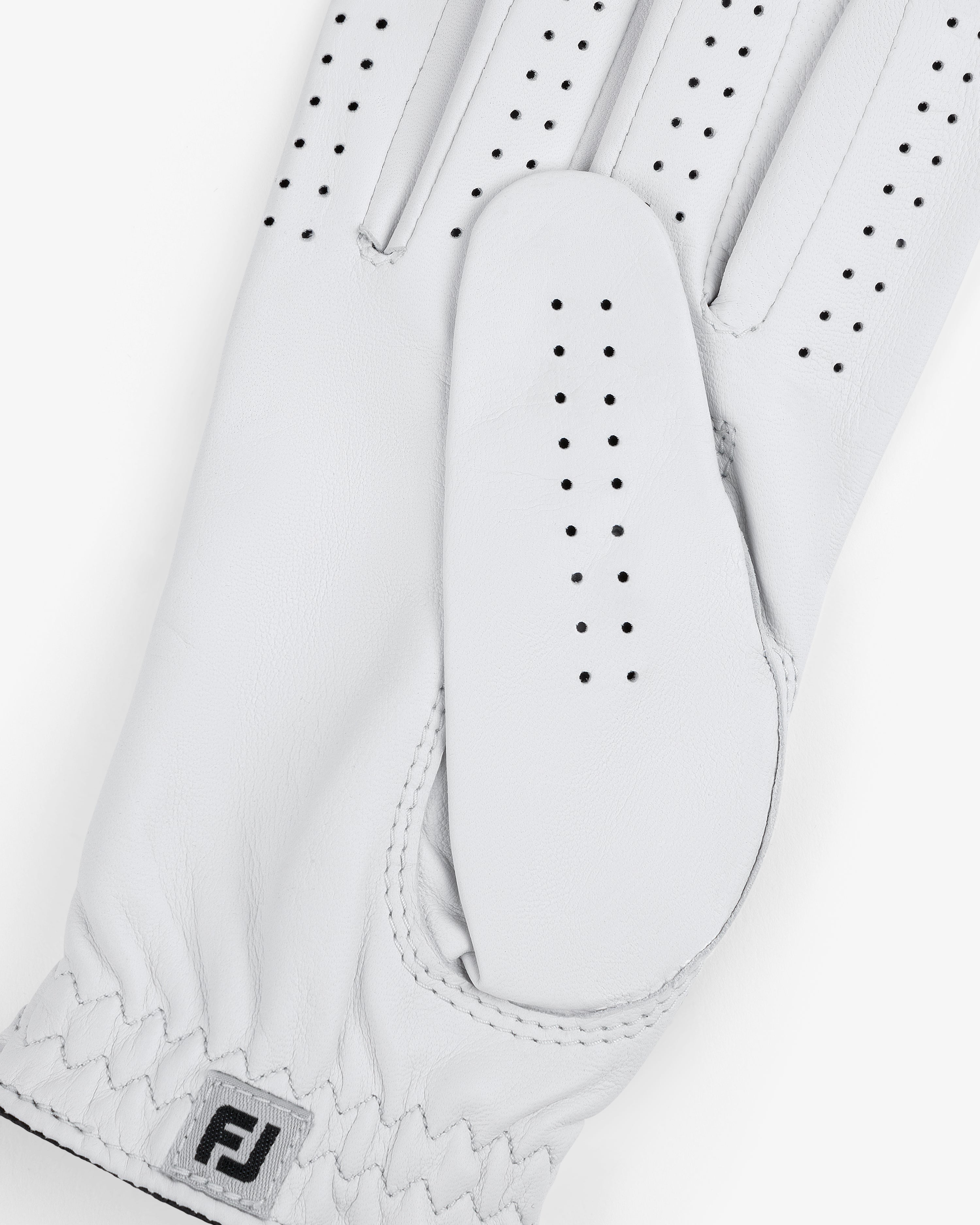 Close-up of the ALD / FootJoy StaSof Heritage Glove (Right) in white leather with perforations and FJ logo by wrist.