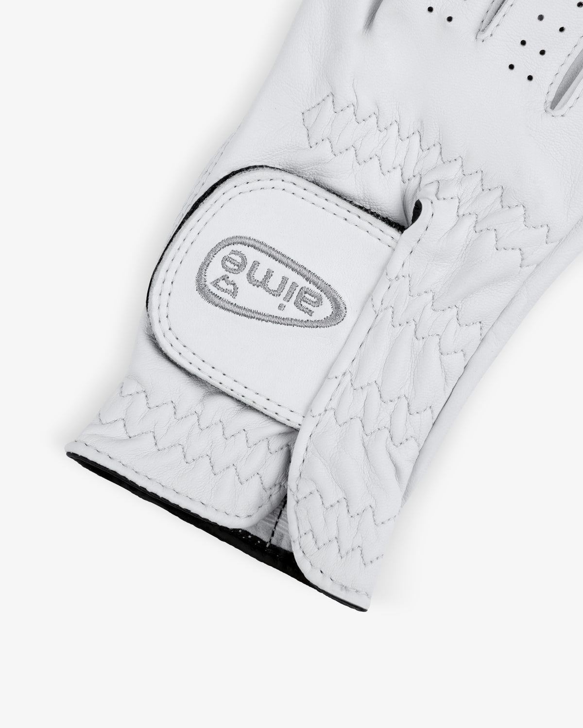 A close-up of the ALD / FootJoy StaSof Heritage Glove (Right) with a stitched strap and gray eimie logo on the fastener.