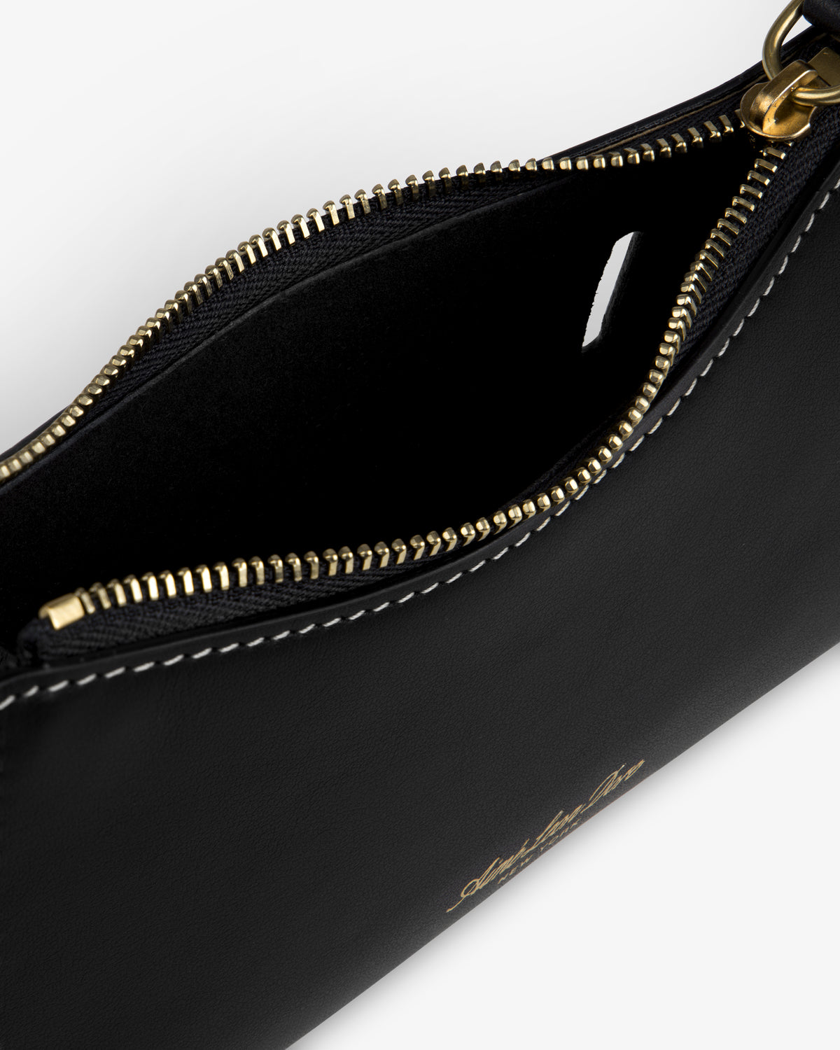 Close-up of an open Convertible Leather Belt Bag in black leather with gold zipper and white stitching.