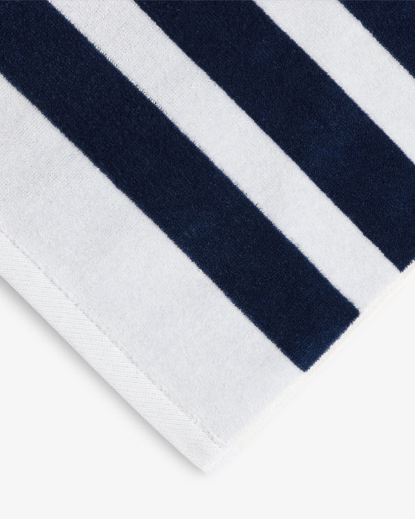 A close-up of the Striped Beach Towel featuring alternating navy blue and white vertical stripes.