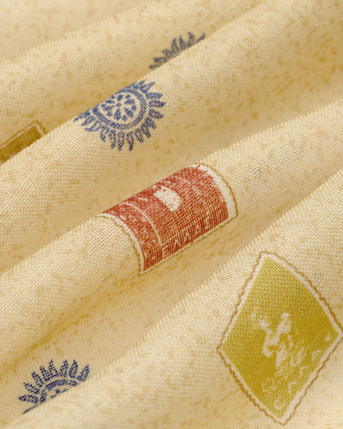 Vintage Stamps Wool Silk Bandana in cream with blue, red, and green geometric and sun-inspired patterns, softly folded.