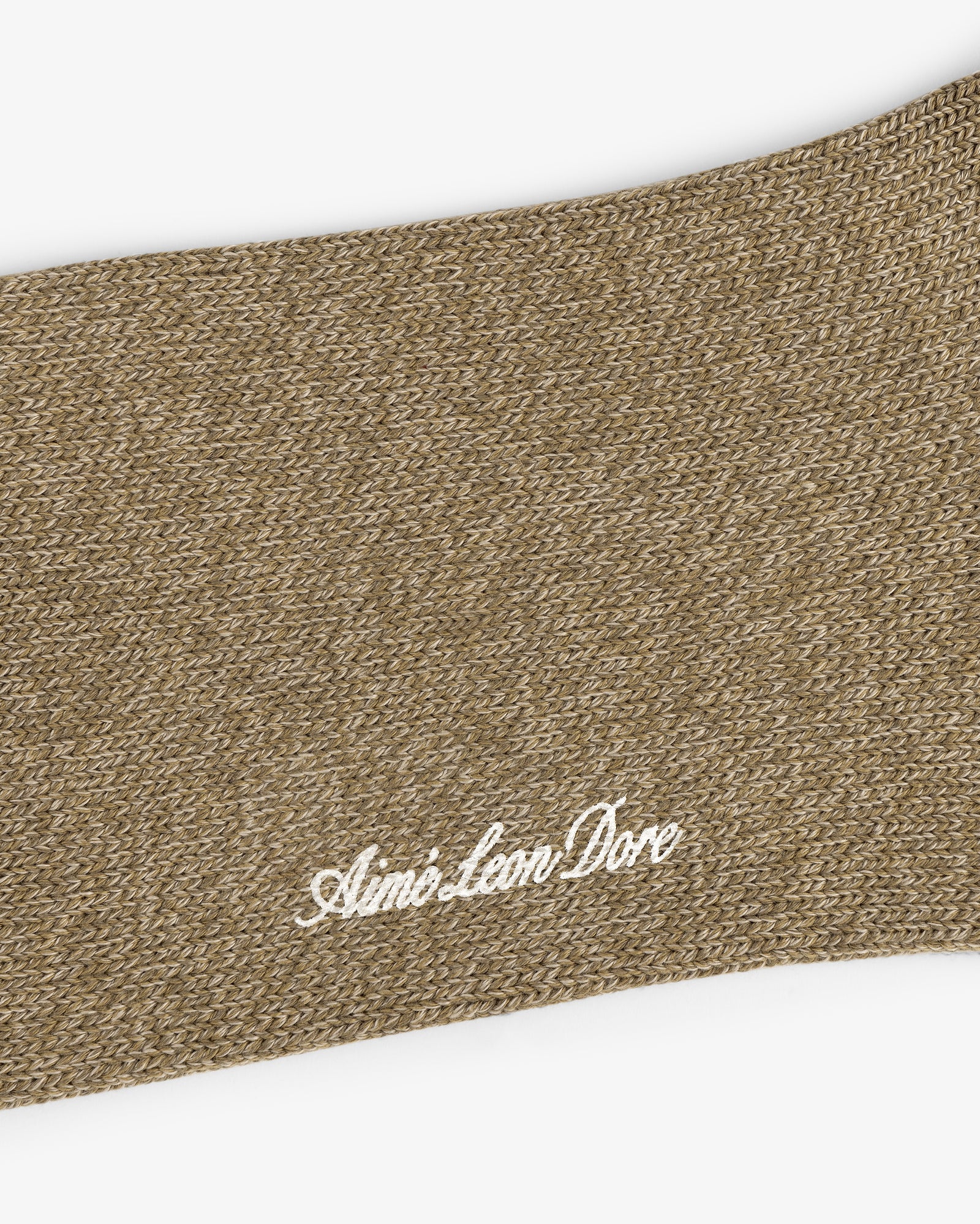 Close-up of a brown knit Marled Quarter Sock with Aimé Leon Dore embroidered in white cursive lettering.