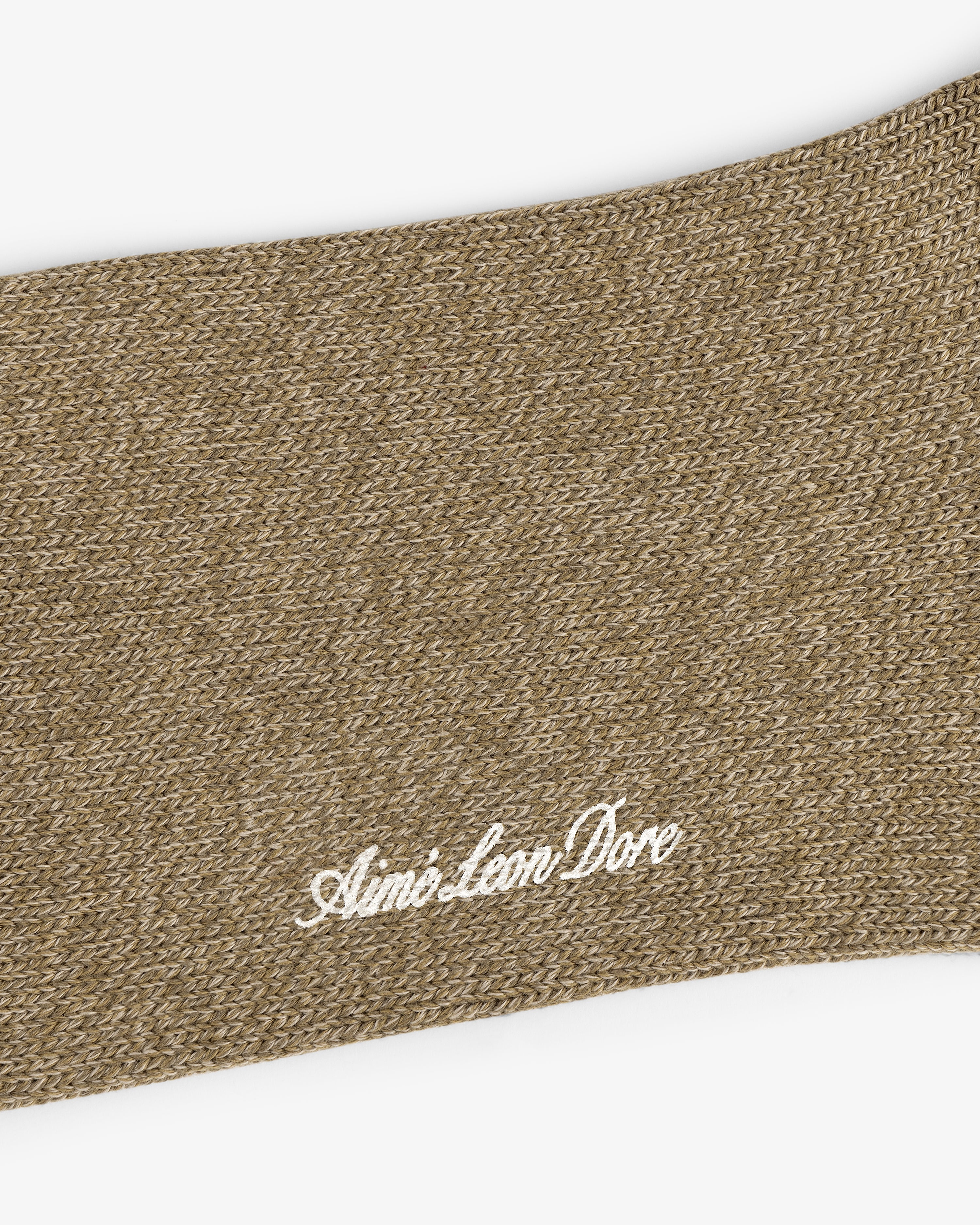 Close-up of a brown knit Marled Quarter Sock with Aimé Leon Dore embroidered in white cursive lettering.