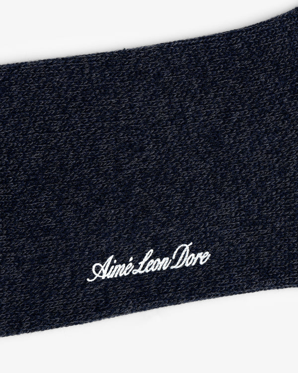 Close-up of dark blue textured Marled Quarter Sock with Aime Leon Dore embroidered in white cursive.