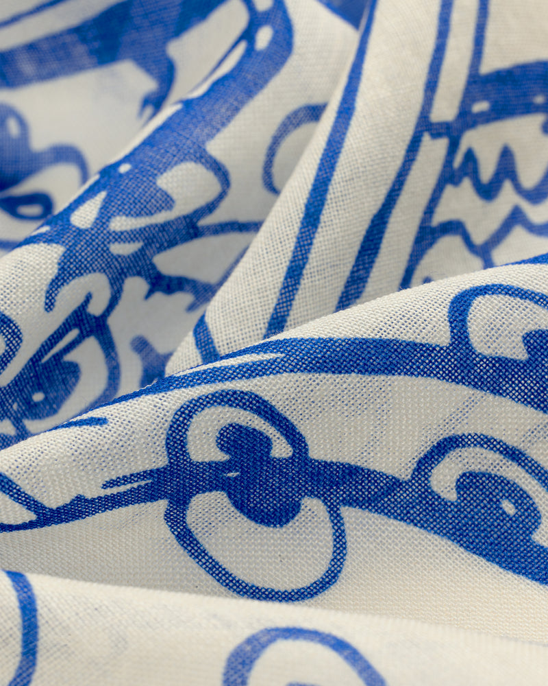 Close-up of the Fassianos Wool Silk Bandana, featuring bold blue abstract patterns and wavy lines on white fabric.