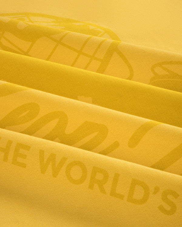 Close-up of folded Sun Faded Unisphere Bandana with faint printed text, including the words THE WORLDS.