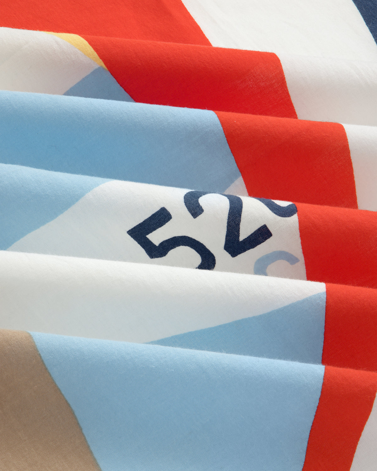 A folded Regatta Bandana with red, blue, beige, and white geometric patterns; number 526 partly visible.