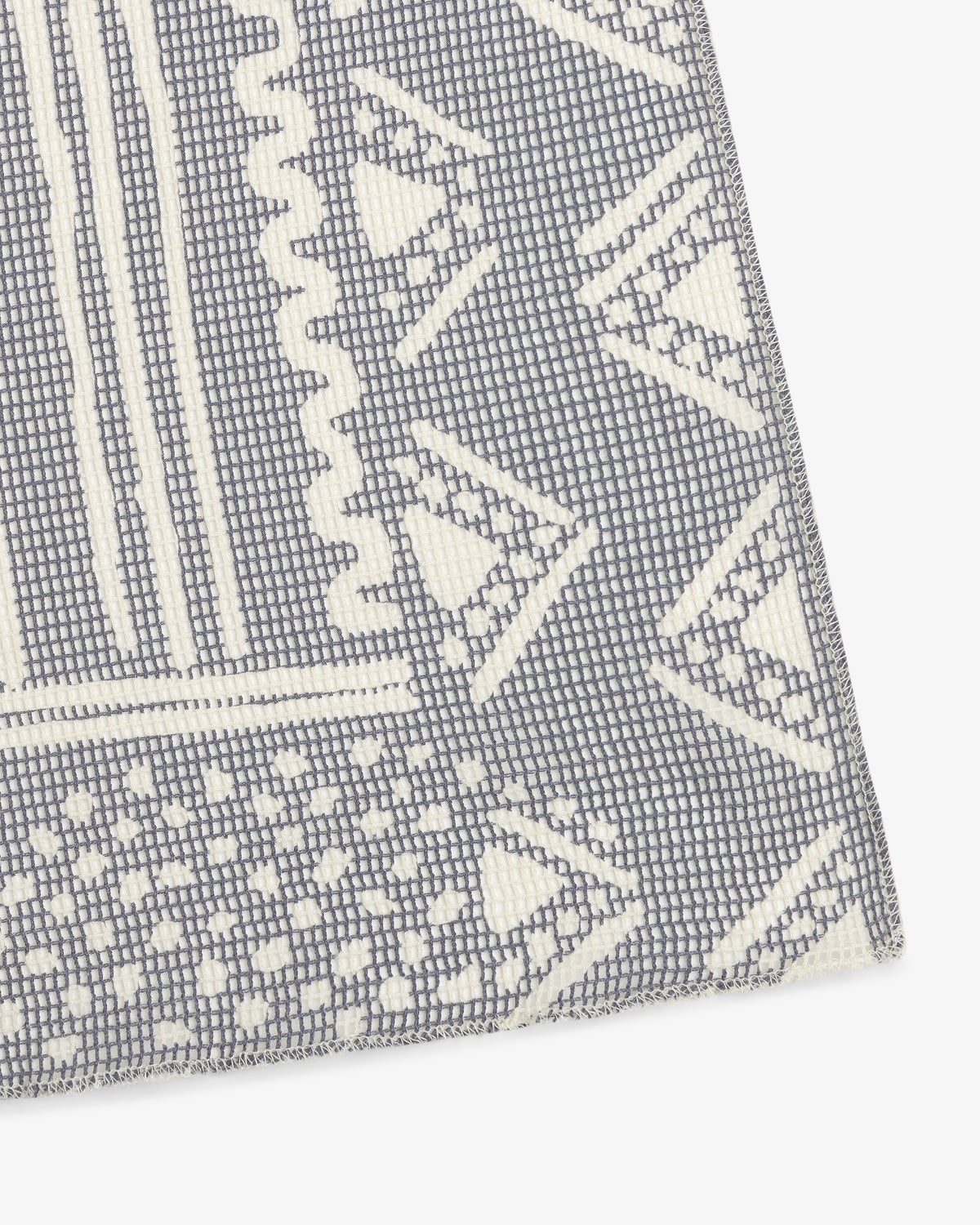 Close-up of the Mesh Tapestry Bandana, showing gray and white geometric patterns with triangles and zigzags.