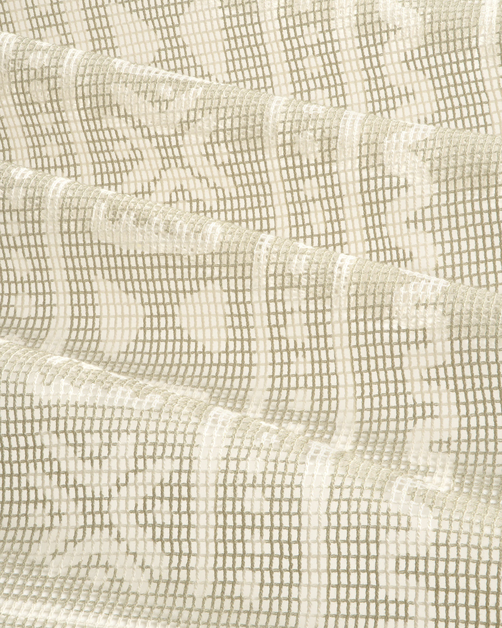 Close-up of the Mesh Tapestry Bandana in cream, featuring a geometric grid and floral pattern, folded in soft waves.
