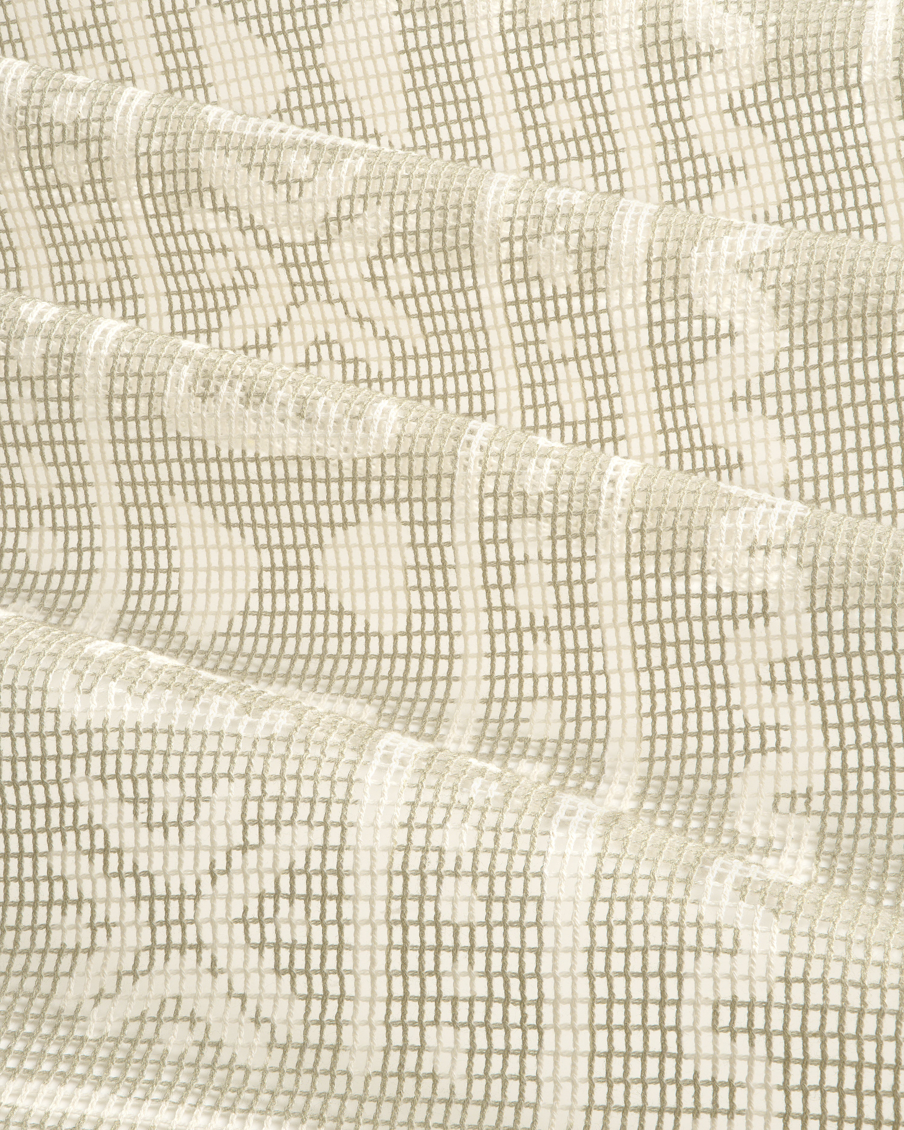Close-up of the Mesh Tapestry Bandana in cream, featuring a geometric grid and floral pattern, folded in soft waves.