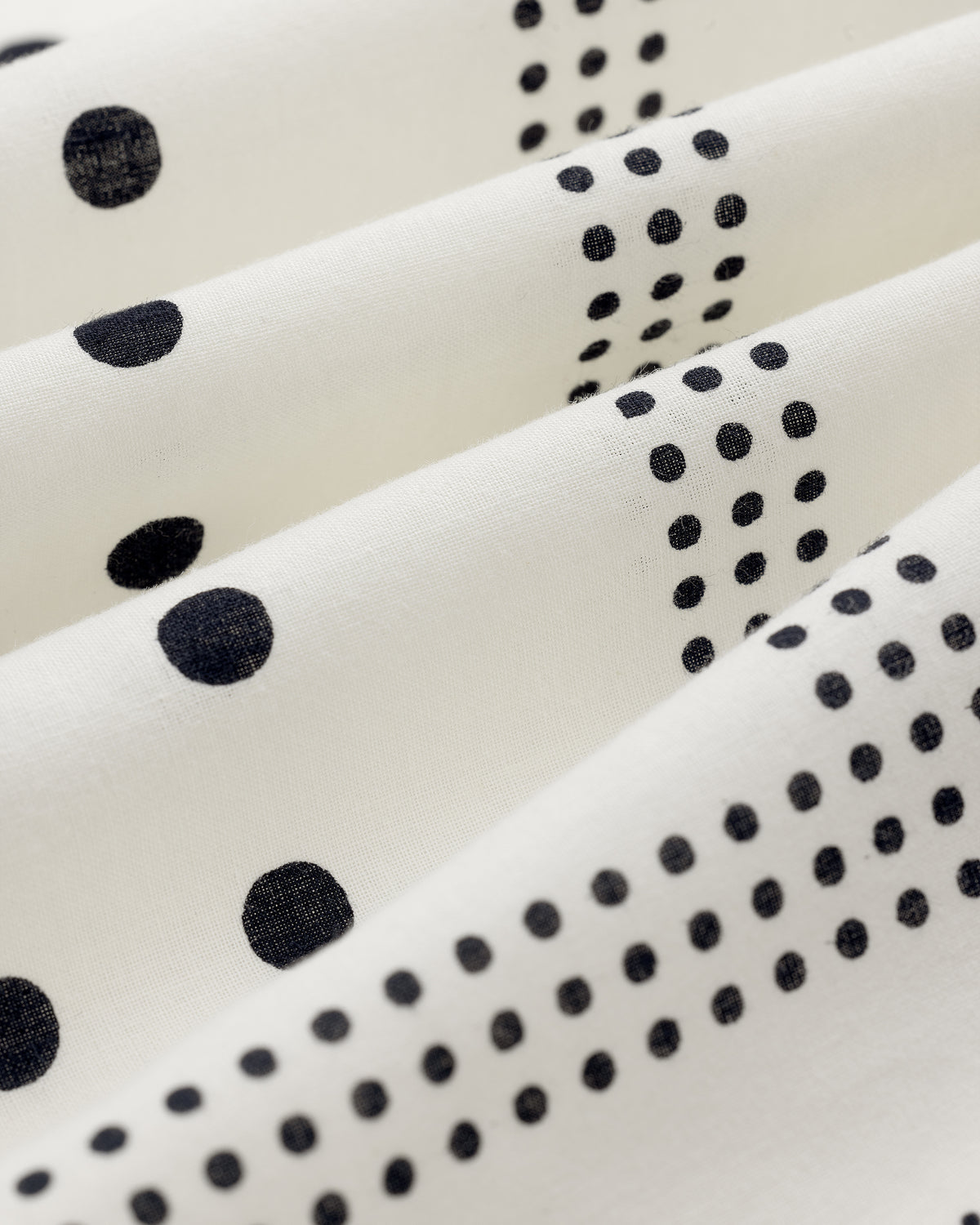 Polka Dot Bandana in white fabric with black dots, draped in soft, evenly spaced folds.