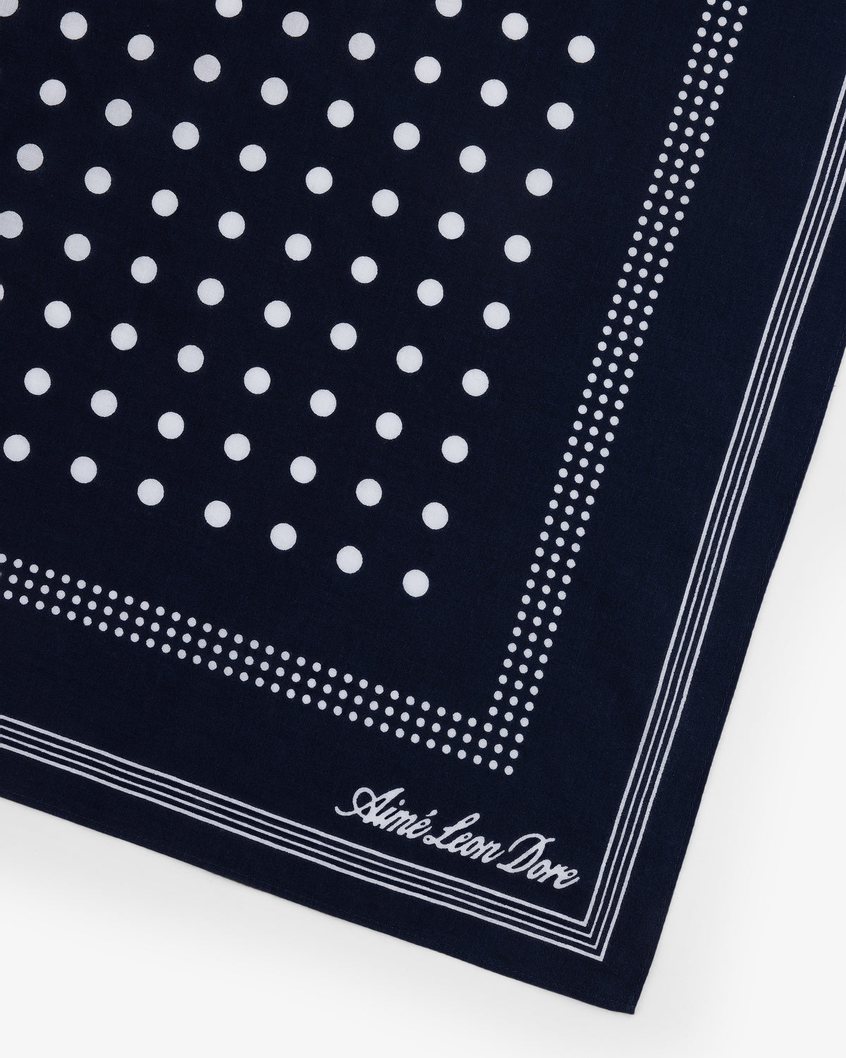 Polka Dot Bandana in navy with white dots, dotted and solid borders, and Aimé Leon Dore script in the corner.